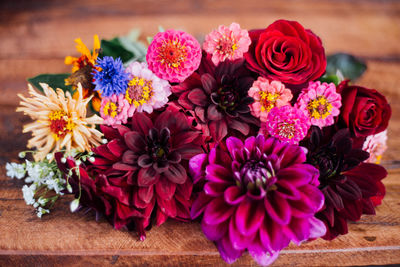 High angle view of various flowers arranged on wooden table