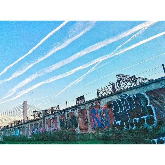 transfer print, built structure, architecture, blue, auto post production filter, low angle view, graffiti, building exterior, sky, connection, power line, clear sky, day, cable, outdoors, city, sunlight, no people, text, art