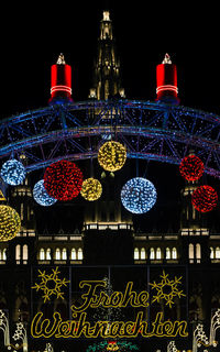 Low angle view of illuminated lights against black background