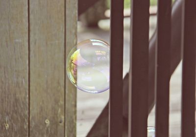 Close-up of bubble by wooden fence
