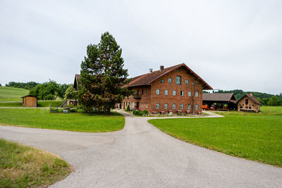 Houses on field by lawn against sky