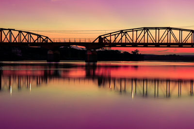 Bridge over river against sky during sunset