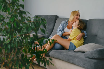 Portrait of young woman sitting on sofa at home