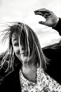 Portrait of smiling woman against sky