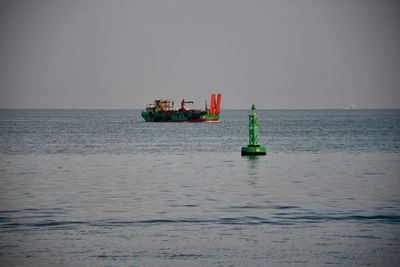 Boat sailing in sea against clear sky