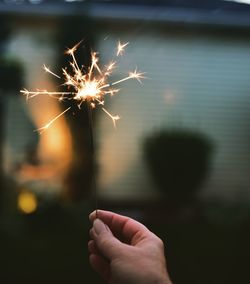 Close-up of hand holding sparkler at night