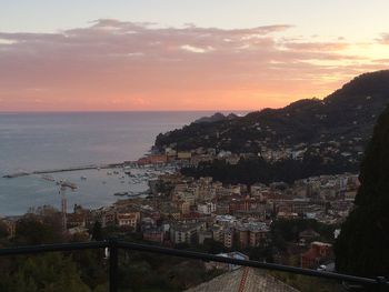 High angle view of townscape by sea against sky during sunset