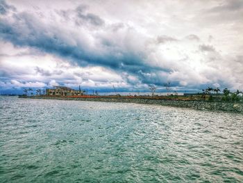 Scenic view of sea by buildings against sky