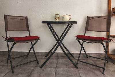 Empty chairs and tables against wall at home