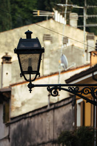 Low angle view of gas light on wall against buildings