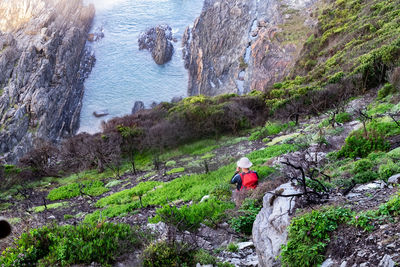 High angle view of man surfing on rock by sea