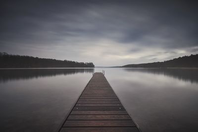 Pier over lake against sky during sunset