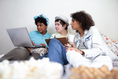 Friends using laptop while sitting at home