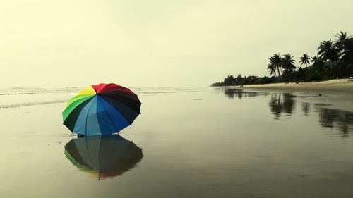 Rear view of person on beach against sky