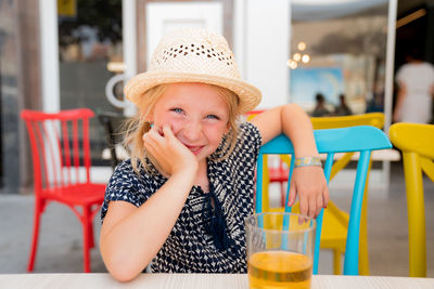 Portrait of cute girl wearing hat on table