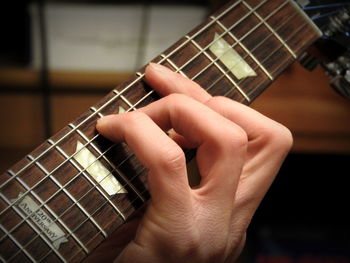 Close-up of hands playing guitar