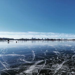 Scenic view of frozen lake against blue sky