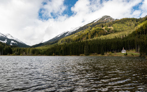 Scenic view of lake by mountains against sky