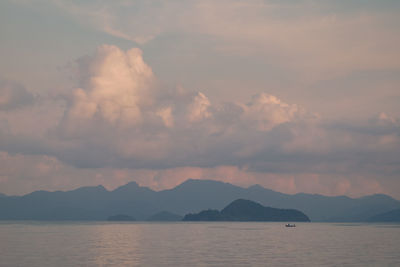 Scenic view of lake by mountains against sky