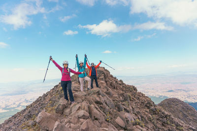 Rear view of man standing on mountain against sky