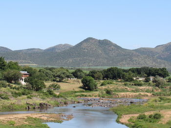 Scenic view of lake and mountains against clear sky