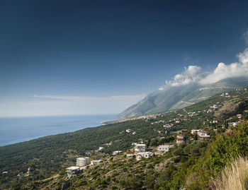 Aerial view of townscape by sea against sky