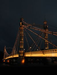 Suspension bridge over river at night