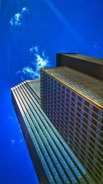 Low angle view of modern building against blue sky