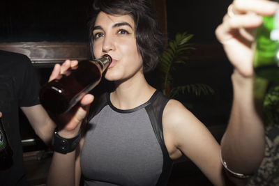 Young woman enjoying a beer at a party