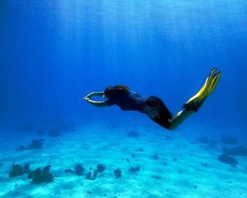 Full length of young woman scuba diving undersea