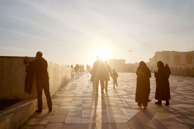 Rear view of people walking on footpath