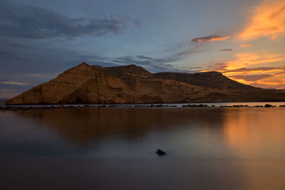 Scenic view of lake by mountains against sky