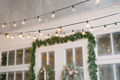 A retro garland of incandescent lamps is lit against the background of the entrance doors to house