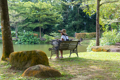 Woman sitting on bench in park