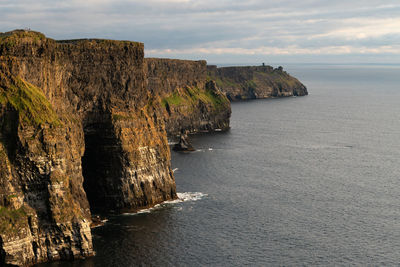 Rock formations by sea against sky