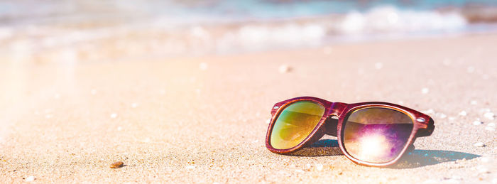 Close-up of sunglasses on sand