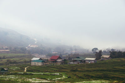 Houses on field against sky