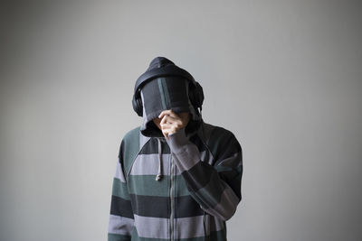 Portrait of teenage girl standing against wall