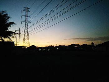 Silhouette electricity pylon against sky during sunset