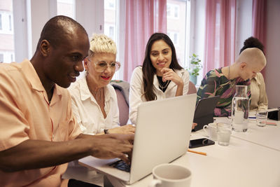 Coworkers sitting at business meeting and talking to each other