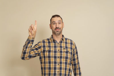 Portrait of young man standing against pink background