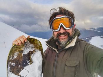 Portrait of man wearing sunglasses while standing on snow