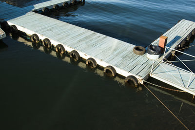 High angle view of tires hanging from jetty in sea