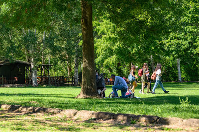 Group of people on grassland against trees