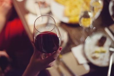 High angle view of hand holding beer glass on table