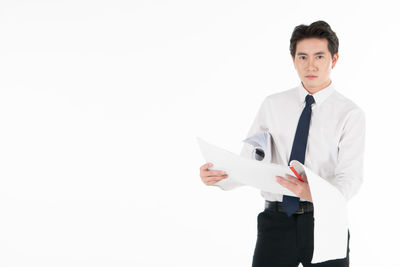 Portrait of young man standing against white background