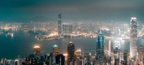 Illuminated cityscape against sky at night