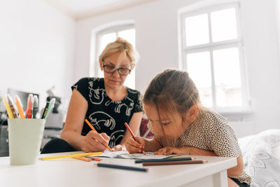 Woman and girl painting at home