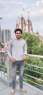 Portrait of young man standing against built structures