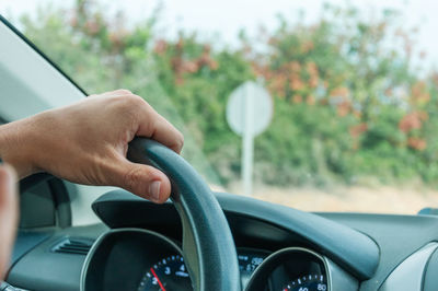 Cropped hand of man driving car